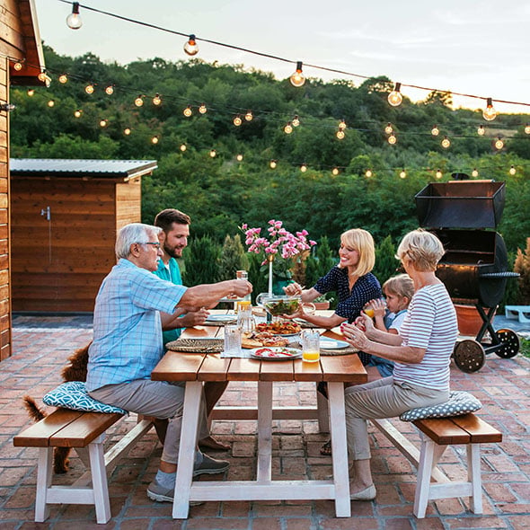 Multi Generational Family enjoying dinner on back patio of new home after getting a mortgage with CCCU home loan