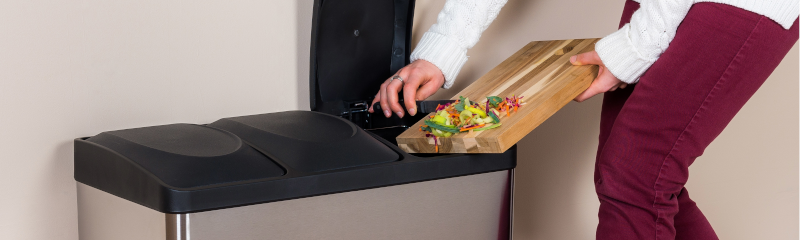 person throwing food waste in trashcan