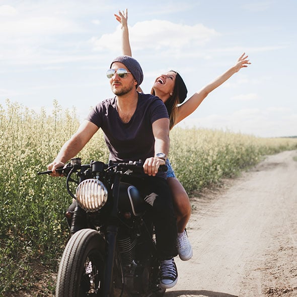 Couple riding a new motorcycle together that was purchased with a motorcycle loan from Consolidated Community Credit Union in Portland Oregon.