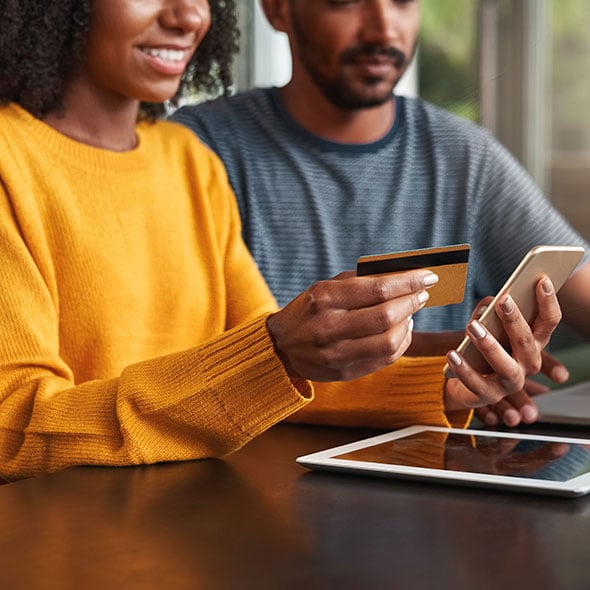 Couple online shopping with funds from Holiday Savings Account from CCCU