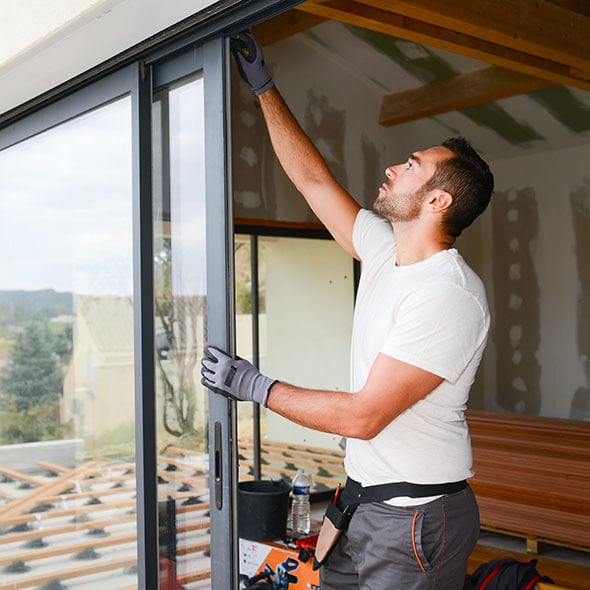 Man installing a door on his house for a home improvement project.