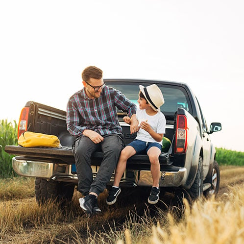 Father and son in the bed of the truck that was purchased with Consolidated Community Credit Union.