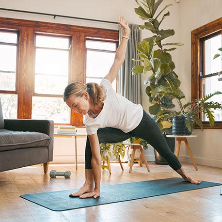 Woman doing yoga in her new home that she purchased with a jumbo loan from CCCU credit union in Portland Oregon.
