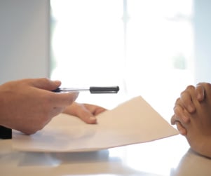 Person hand pre-approval letter to person to sign