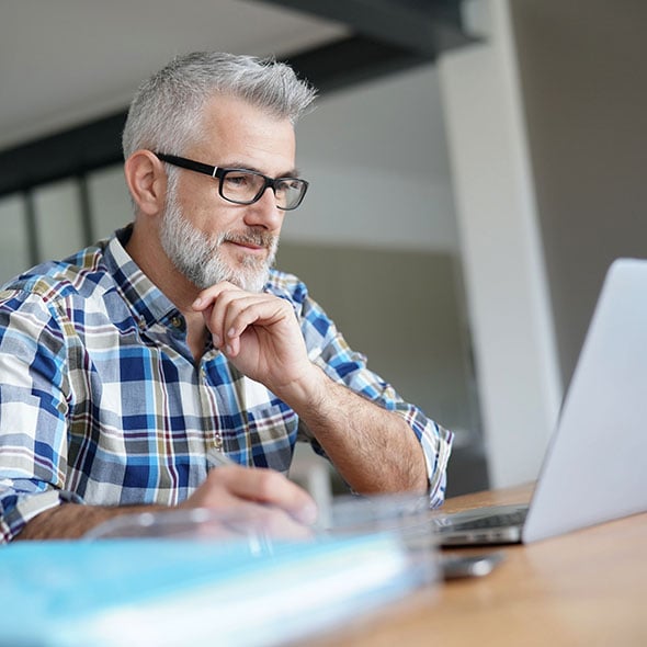 Man on computer applying for a personal loan through Consolidated Community Credit Union CCCU in Portland Oregon.