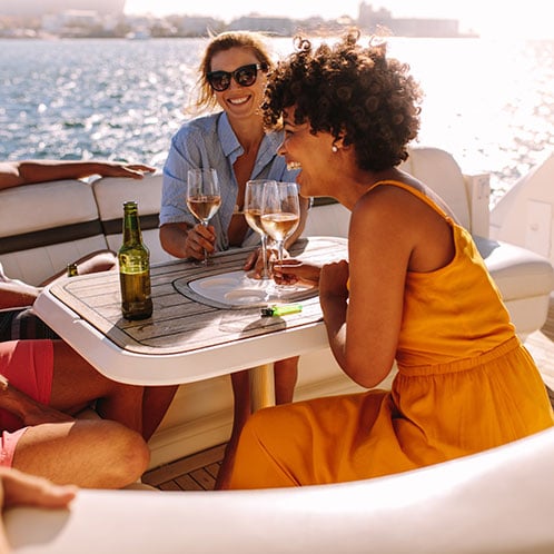 Woman smiling on a new boat with her friends on a sunset cruise 