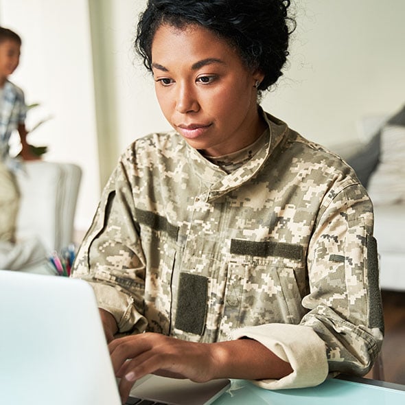 Woman in military filling out online application for VA loan through CCCU credit union.