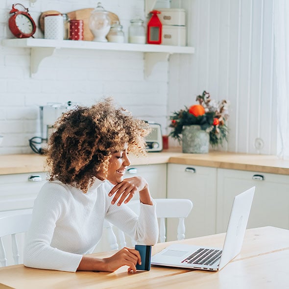 Woman banking on computer using CCCU online banking services.