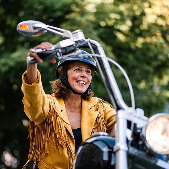 Woman on a motorcycle she purchased with a motorcycle loan from consolidated community credit union.