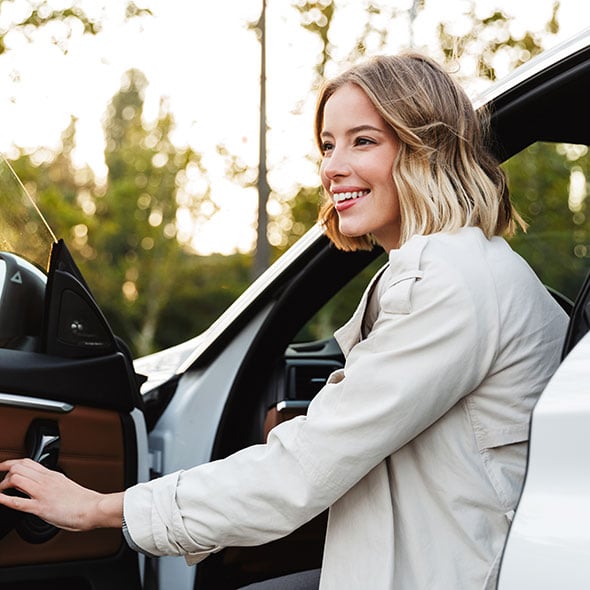 Woman opening door of her new dream car that she purchased with the best auto loan in Portland Oregon.