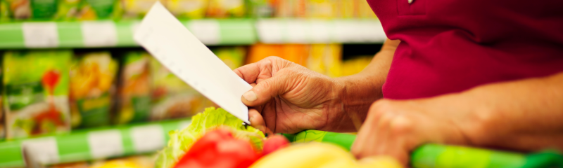 woman saving money on groceries by using a grocery list