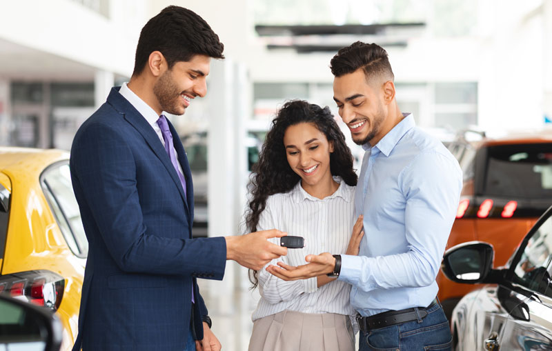 Middle-eastern-couple-smiles-while-receiving-car-keys-after-learning-the-msrp-meaning-and-how-to-negotiate-a-great-car-price.