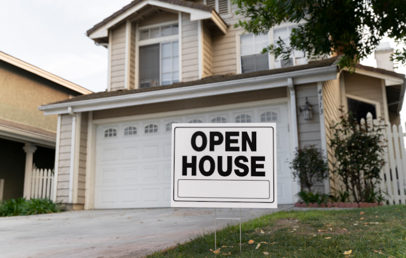 house with open house yard sign in front yard