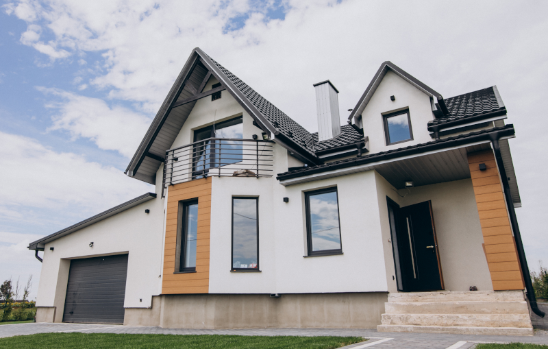 the exterior of a modern white and wood house