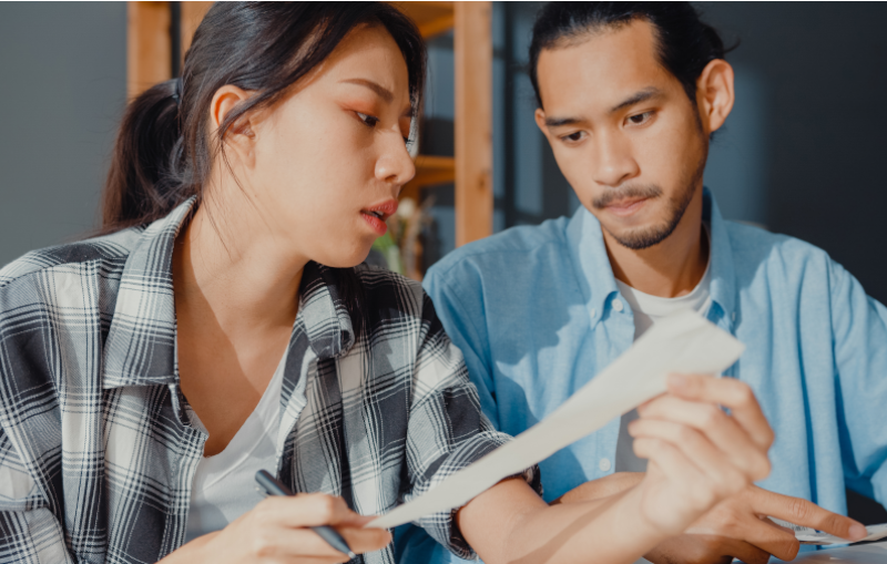 young asian couple reviewing receipts of their expenses for their budget