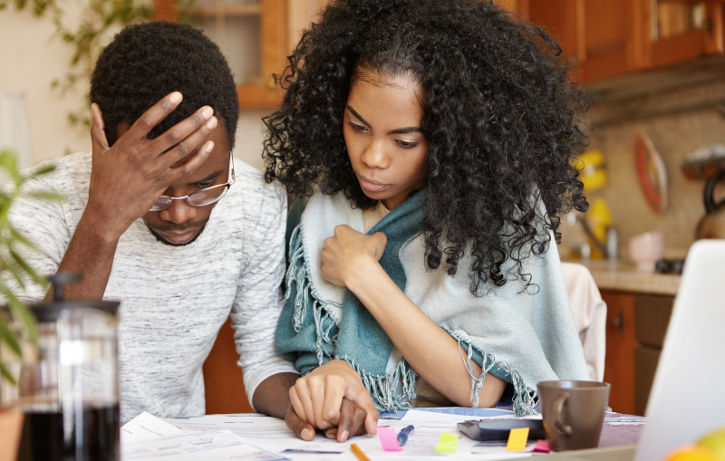 young black couple stressed about paying off their debt
