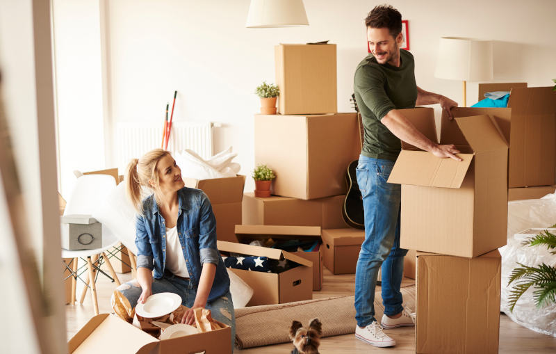 young couple and small dog move into their first home