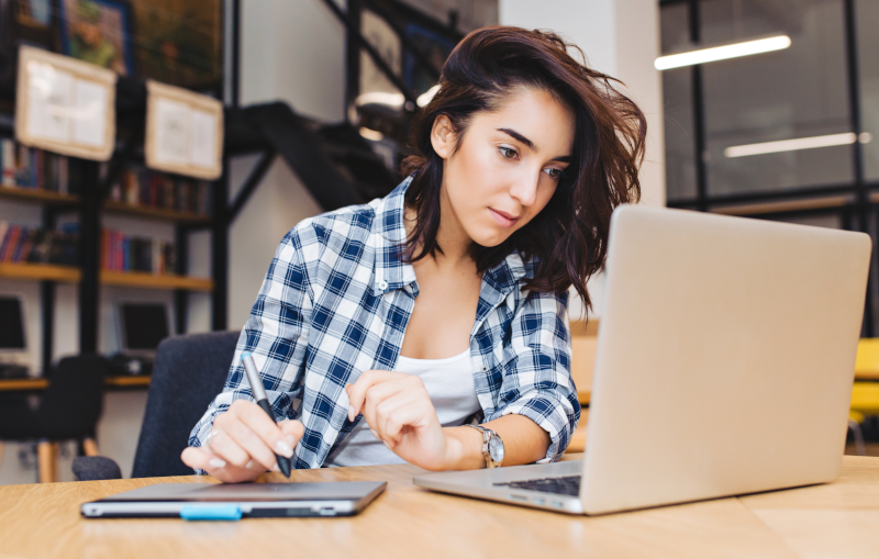 young woman researching mortgage lenders on her laptop